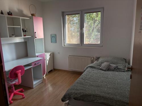 a small bedroom with a bed and a desk at Apartman L&L in Sarajevo