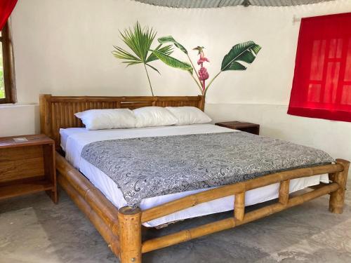 ein Schlafzimmer mit einem Holzbett und einer Pflanze an der Wand in der Unterkunft Great Hostels Amazon in Puyo