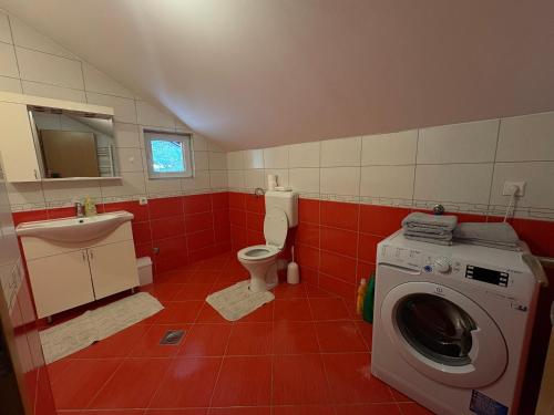 a bathroom with a washing machine and a toilet at Apartman L&L in Sarajevo