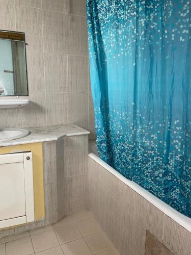 a bathroom with a shower curtain and a sink at Sweet Home in Tunis