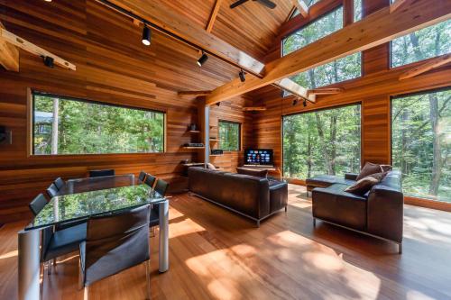 a living room with leather furniture and large windows at Phoenix Chalets by HHG in Hakuba