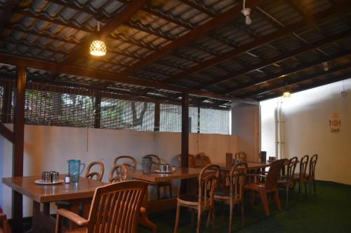 a dining room with wooden tables and chairs at Naisarga hill view homestay in Somvārpet