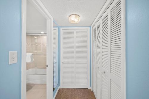 a bathroom with a walk in closet with white doors at Beachfront End Unit 302 2 Bikes beach gear in Sanibel