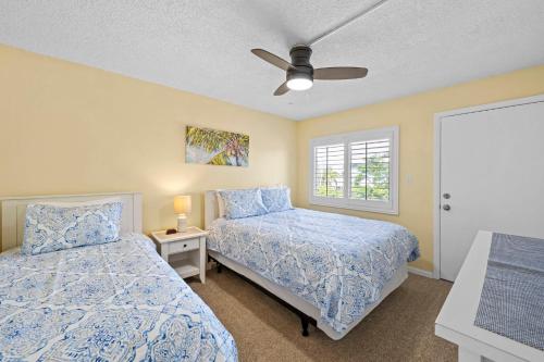 a bedroom with two beds and a ceiling fan at Beachfront End Unit 302 2 Bikes beach gear in Sanibel