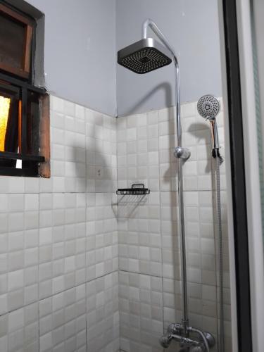 a shower with a shower head in a bathroom at Rose Pearl Apartment in Entebbe