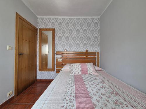 a bedroom with a bed with a dresser and a mirror at Casa Güelo in Muros de Nalón