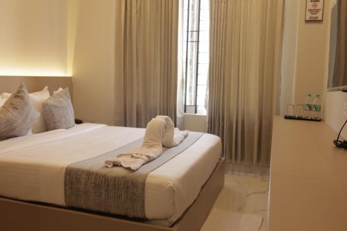 a hotel room with a bed with towels on it at Hotel Nevesa Devanahalli in Bangalore