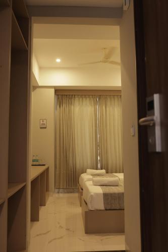 a hotel room with two beds and a window at Hotel Nevesa Devanahalli in Bangalore