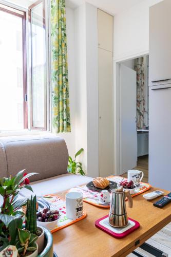 a dining room table with food on top of it at Casa DiMì - 2 BR, 2 en-suite bath, 2 min M5, Smart lock in Milan
