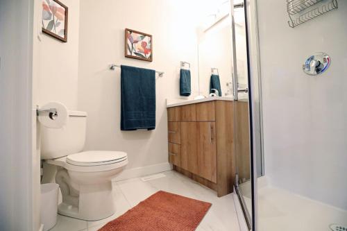 a bathroom with a toilet and a sink and a shower at Central 3 Queen Beds AC Double Garage Disney in Edmonton
