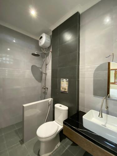 a bathroom with a white toilet and a sink at Villa New IMS in Bandung
