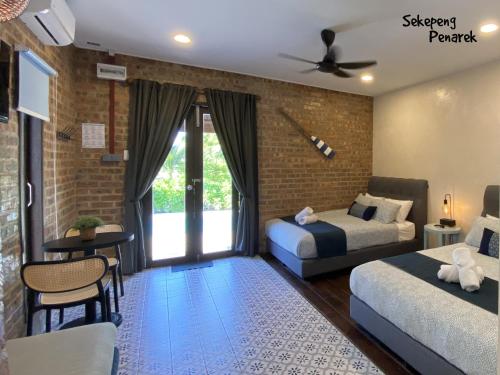 a bedroom with two beds and a brick wall at Sekepeng Penarek II in Kampung Penarik