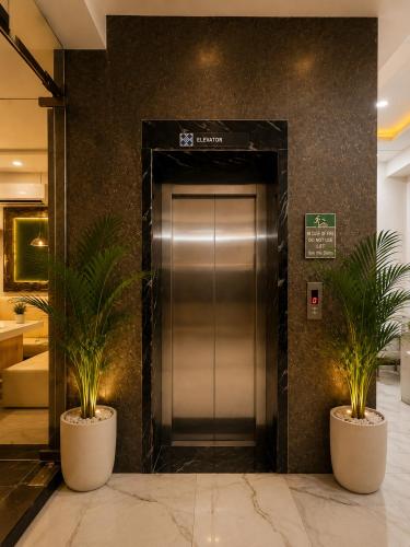 an elevator in a building with two potted plants at Hotel Star Grand - Premium Budget Hotel Near Taj mahal, in Agra
