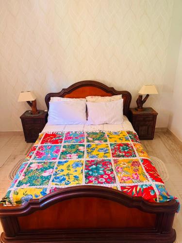 a bed with a colorful quilt on top of it at Cheiro de Flor - Gamarra in Baependi