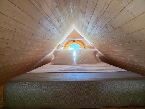 a bed in a small room with a small window at Ailéa Tiny House avec jacuzzi privatif in Beaumes-de-Venise