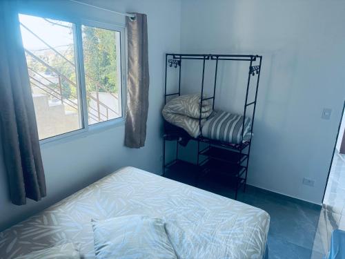 a room with a bed and a room with a window at Refúgio dos ventos in Campos do Jordão