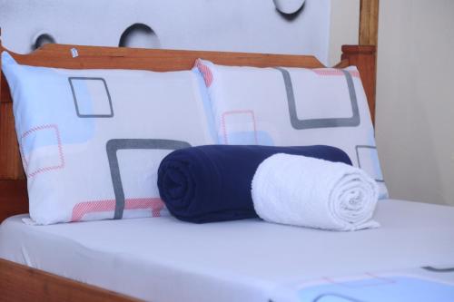 a bed with a roll of towels on it at La Bella resort in Mombasa