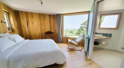 a bedroom with a bed and a desk and a window at Maison Ciaran in Trébeurden