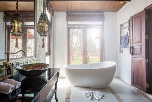 a bathroom with a large white tub and a sink at Sriwilai Sukhothai in Sukhothai