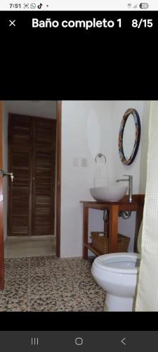 a bathroom with a sink and a toilet and a mirror at Casa puerto in Progreso