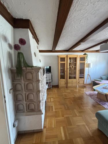 un soggiorno con pavimenti in legno e soffitto di MaRe FeWo a Hettingen