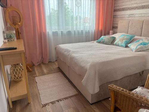 a bedroom with a bed and a desk and a window at Apartament Color4you Blue in Wschowa