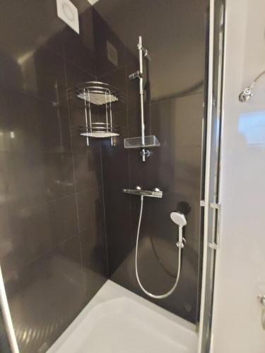 a shower with a shower head in a bathroom at domek Lawendowy na wiejskiej in Lubiatowo