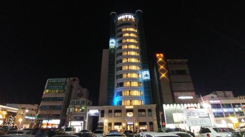 a tall building with lights on top of it at night at Gangneung Tourist Hotel in Gangneung