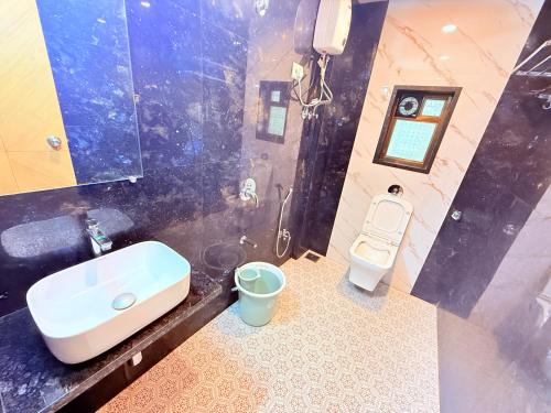 a bathroom with a sink and a toilet at Hotel Kanaka Residency in Mangrul