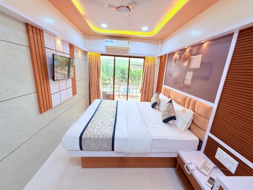 a bedroom with two beds in a room with a tv at Hotel Kanaka Residency in Mangrul