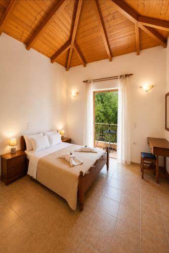 a bedroom with a large bed and a large window at Delphinus Villa Nefeli in Agios Nikitas
