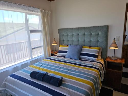 ein Schlafzimmer mit einem großen Bett mit blauen und gelben Streifen in der Unterkunft Die Ateljee in Glentana