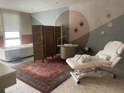 a bathroom with a tub and a chair and a bath tub at DOMITYS - Purpan Pèira Ròsa in Toulouse
