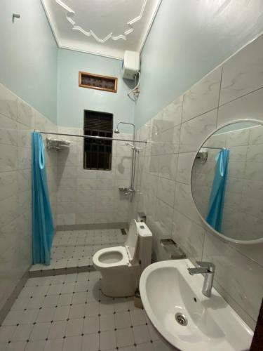 a bathroom with a toilet and a sink and a mirror at Gibson Motel in Mbarara