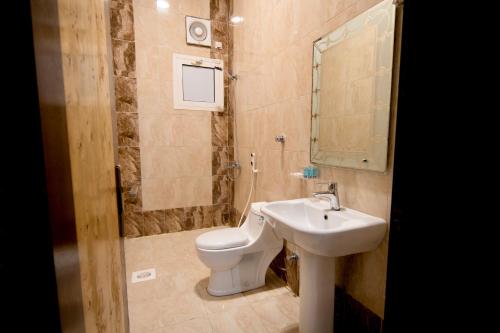 a bathroom with a toilet and a sink at شقق راف التميز in Umm Salam