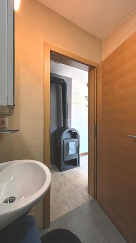 a bathroom with a white sink and a fireplace at Apartment Volk Turjaški in Gabrovka