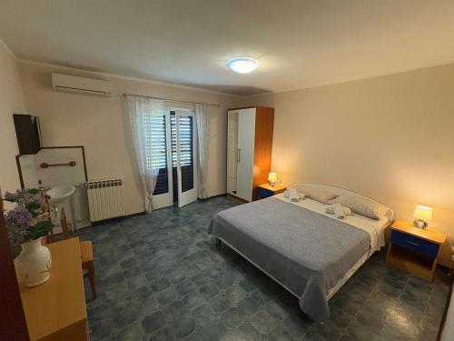 a bedroom with a bed and two tables and two lamps at Apartments & Rooms Ribarić in Lovran