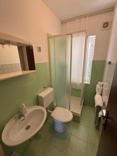 a bathroom with a sink and a toilet and a shower at Apartments & Rooms Ribarić in Lovran
