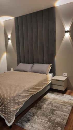 a bedroom with a large bed with a gray headboard at Agel Inn Apartments Mavrovo in Mavrovo