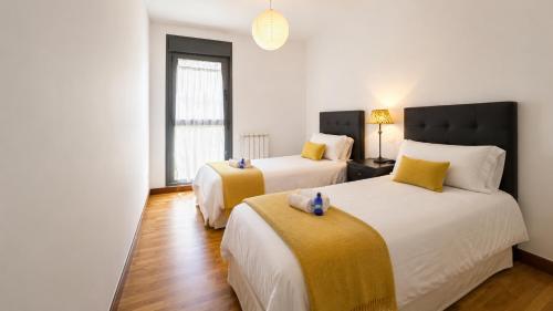 a bedroom with two beds and a window at Apartamento Golf Rioja Alta in Cirueña