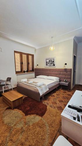 a bedroom with a large bed and a rug at Vizion Hotel in Shkodër
