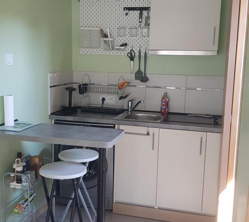 a kitchen with a sink and a counter with stools at Mayka in L'Isle-sur-la-Sorgue