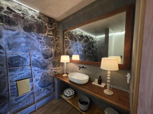 a bathroom with a sink and a mirror at Les Terrasses Suites in Calheta