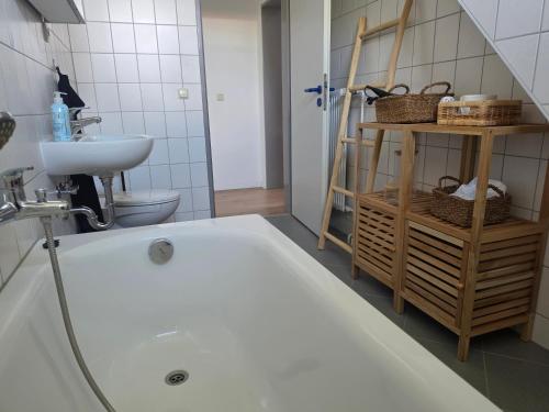 a bathroom with a bath tub and a sink at Gemütliche Ferienwohung in Neubrandenburg