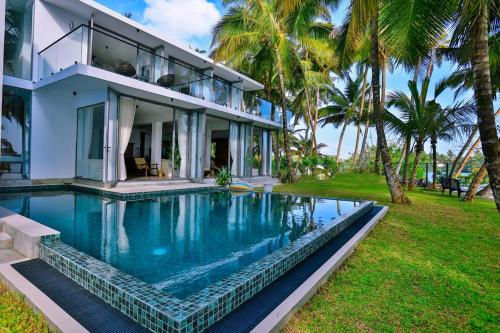 a house with a swimming pool in front of a house at Infinity Whisper in Kosgoda