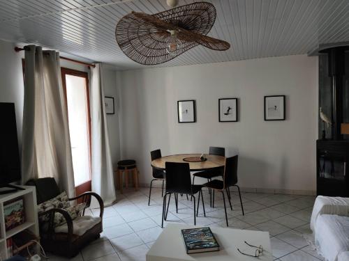 a living room with a table and a ceiling fan at Nahia Etxea agréable maison de 3 chambres in Ciboure
