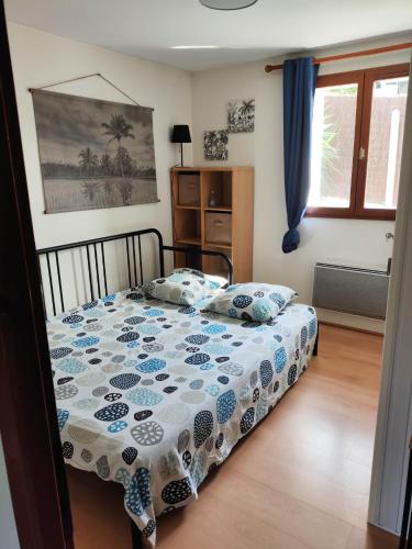a bedroom with a bed with a blue and white comforter at Nahia Etxea agréable maison de 3 chambres in Ciboure