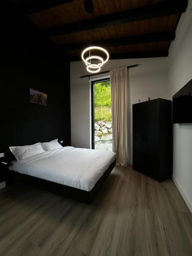 a bedroom with a large bed and a window at Aer & Rowa Chalets by Ekow in Statjunea Borsa