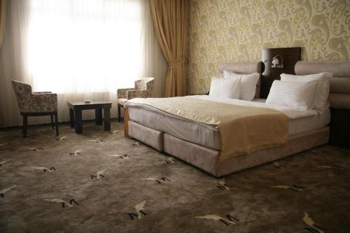 une chambre avec un grand lit et une fenêtre dans l'établissement Blue Mercury Hotel, à Erbil