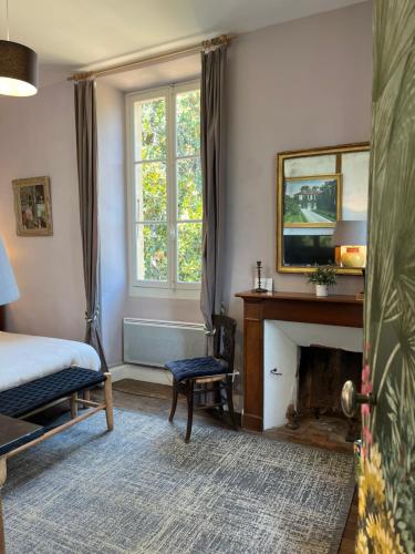 a bedroom with a bed and a fireplace at LA SEIGNEURIE DE TILLAC in Tillac
